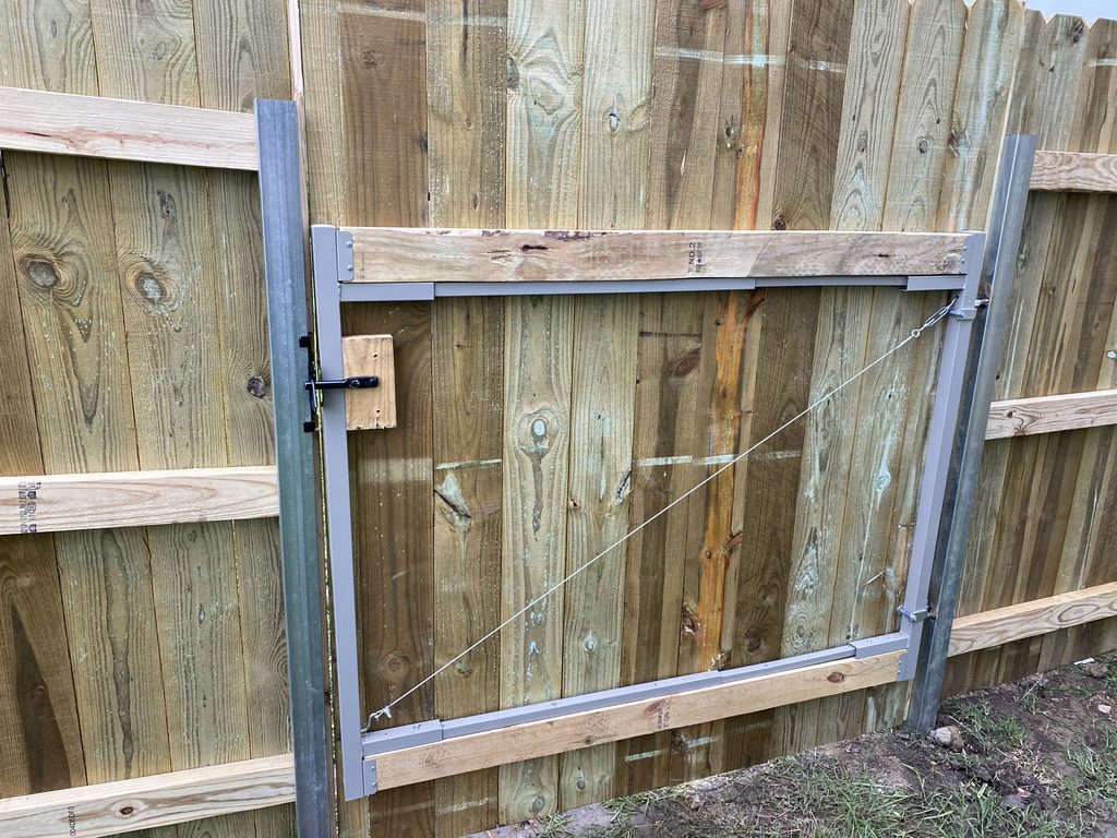 Wood walk gate with metal posts and supporting framewrk.